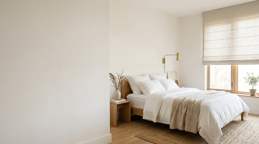 Natural linen roman shade in a calm bedroom — made to measure, blackout lining optional