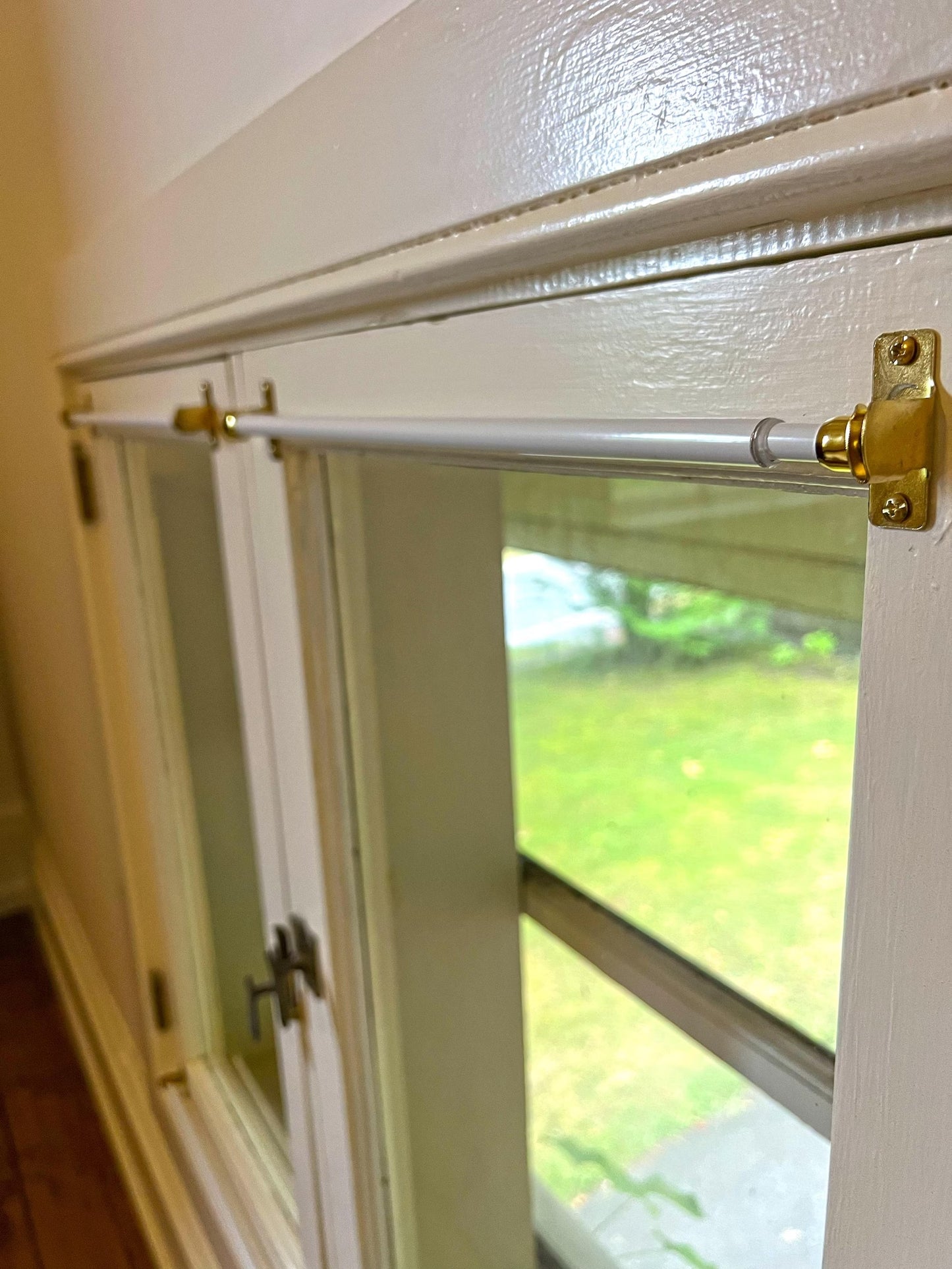 Mounting bracket detail with screw, installed on a window frame