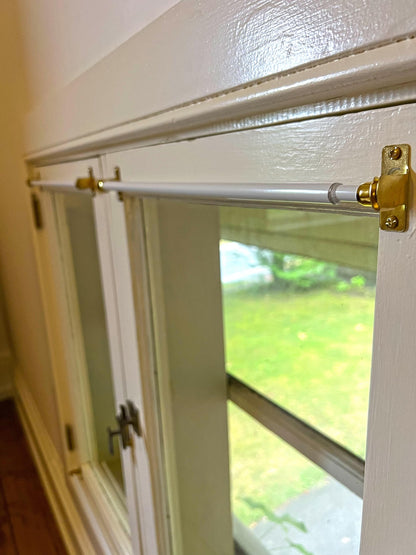 Mounting bracket detail with screw, installed on a window frame