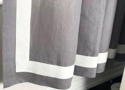 Grey faux-linen curtains with white border on a window