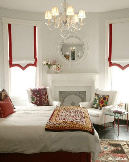 Relaxed roman shade in white with a bright scalloped three-side border, chain mechanism