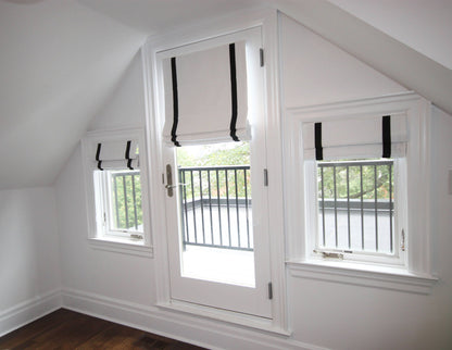 Aran linen flat Roman shades, white with black border, on three windows — custom size