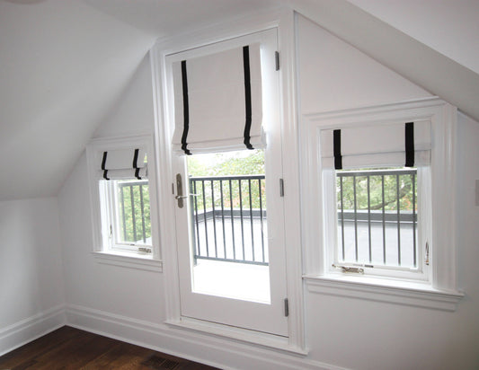 Aran linen flat Roman shades, white with black border, on three windows — custom size