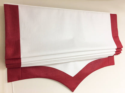 Side border detail of a handmade relaxed roman shade with scalloped trim