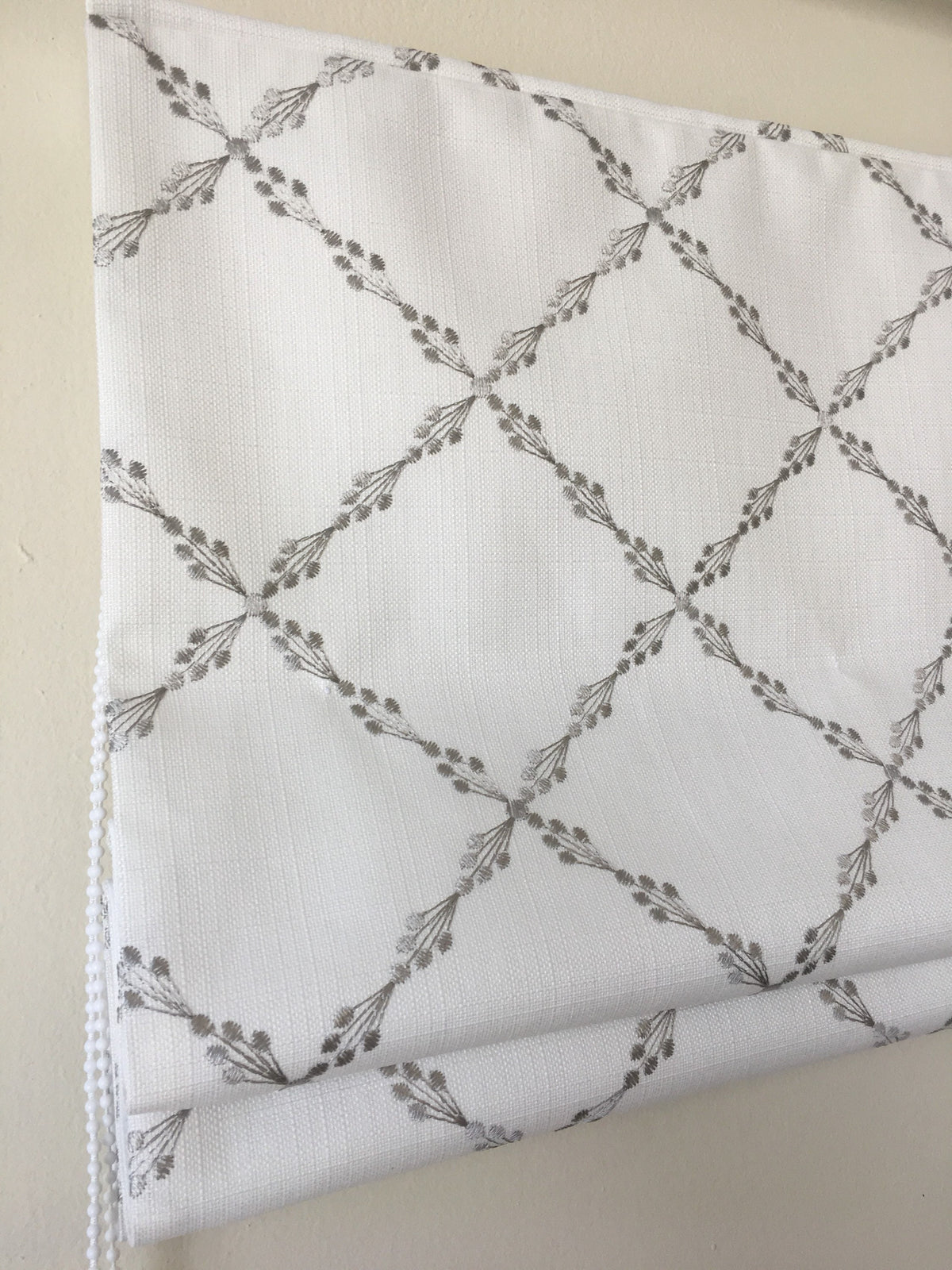 Close view of the grey embroidered diamond repeat on Ryder Silver faux linen