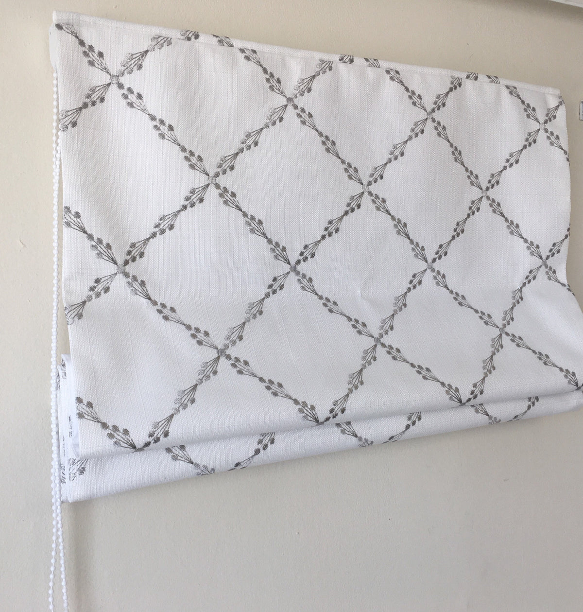 Ryder Silver relaxed Roman shade in white faux linen with grey embroidered sprig pattern