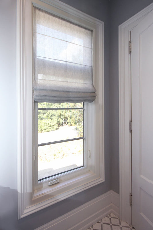 Light grey sheer linen relaxed Roman shade in a bright window — custom made in Toronto