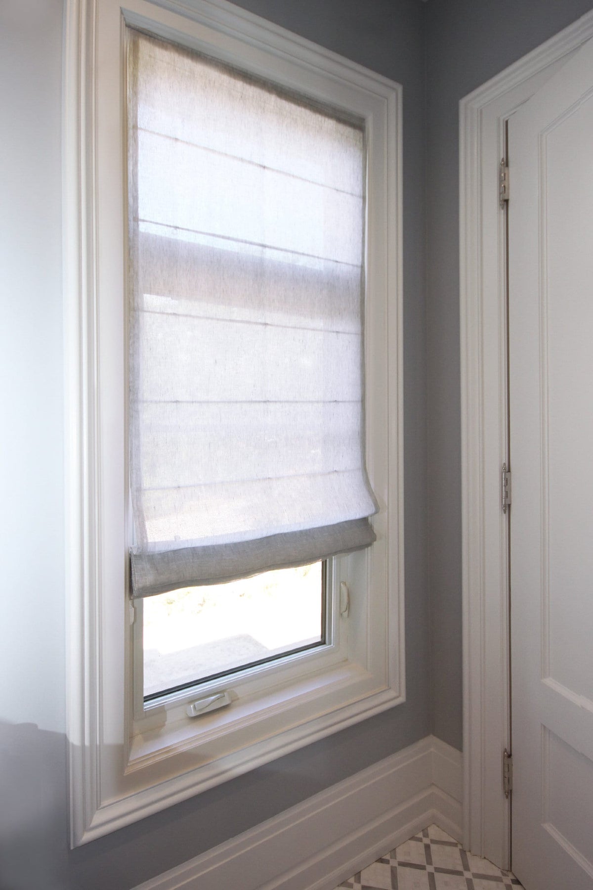 Sheer linen relaxed Roman shade seen from inside the room