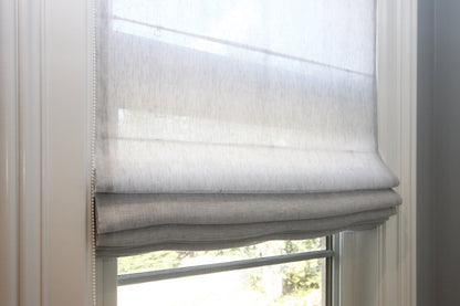 Sheer linen Roman shade — soft relaxed fold with daylight coming through