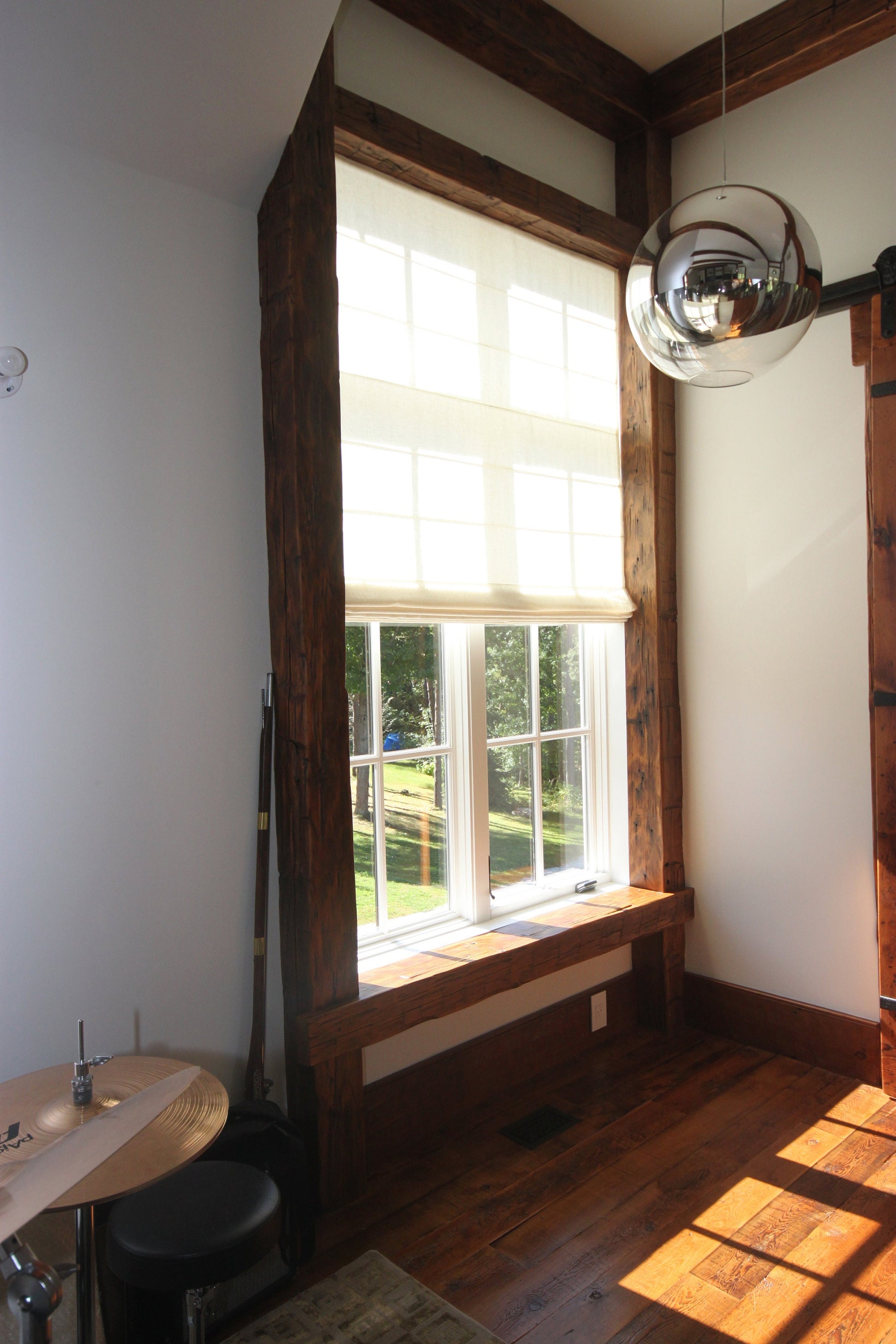 Utopia linen flat Roman shade filtering soft daylight in a sunlit window — LOGANOVA