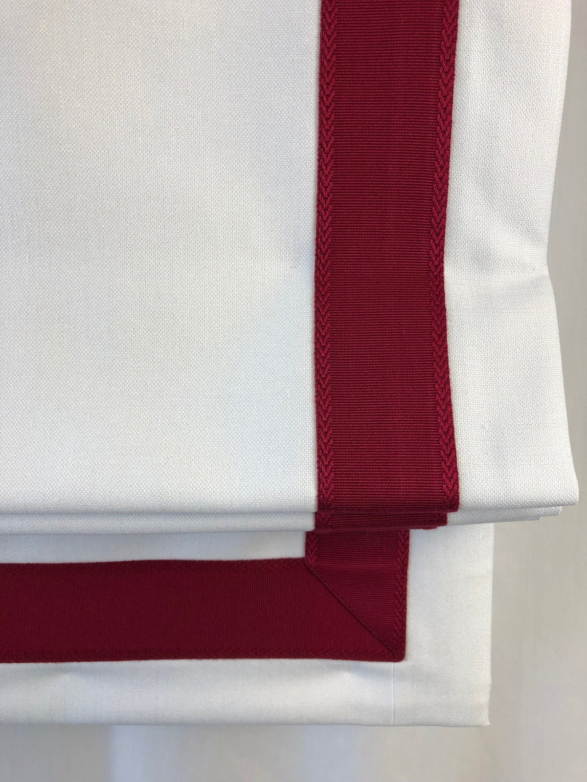 Heart trim detail along the leading edge of a Winter faux linen Roman shade