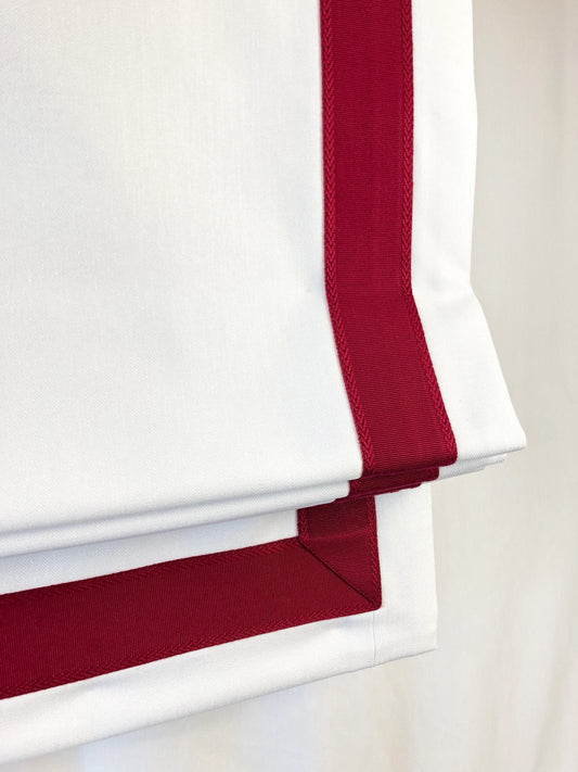 Winter faux linen relaxed Roman shade with Heart contrast trim, hung in a window