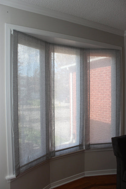 Three Utopia sheer linen relaxed Roman shades fitted on a bay window — LOGANOVA