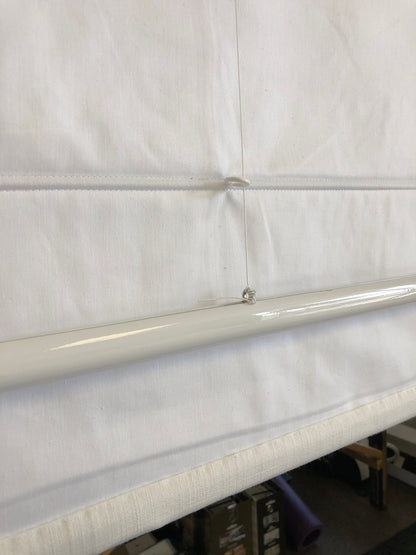 Back of a white Roman shade showing the premium lining and weighted bottom bar