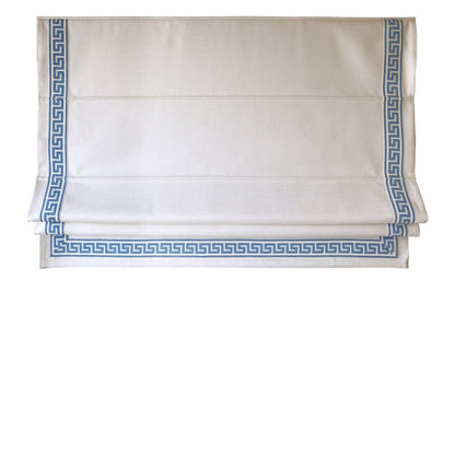 White flat Roman shade with blue Greek key trim raised in clean horizontal folds