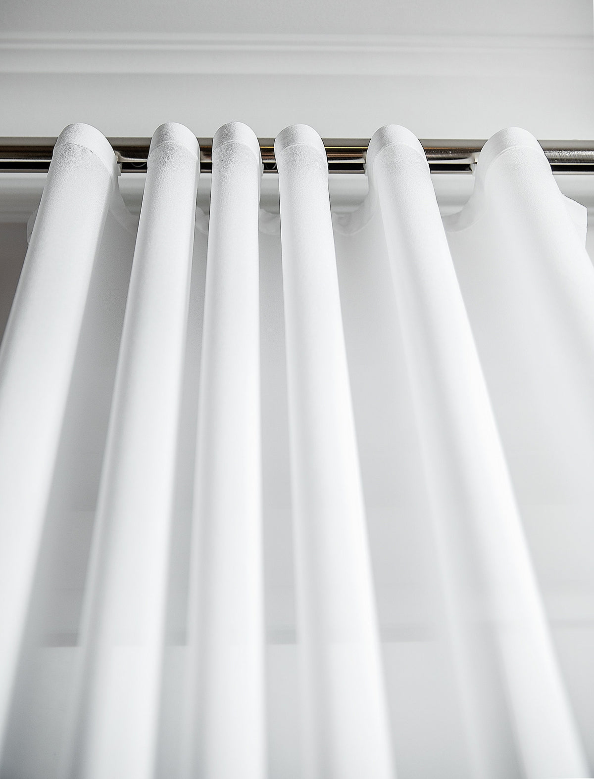 Close view of the Kidman sheer fabric showing its fine grain and matte finish along an s-fold curve