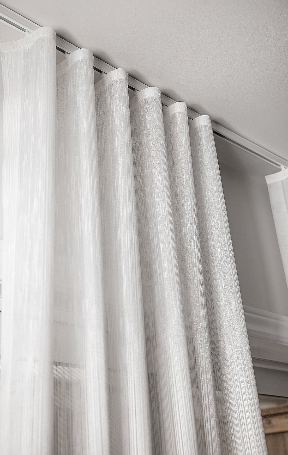 Lugano sheer S-fold curtain filtering daylight in a living room
