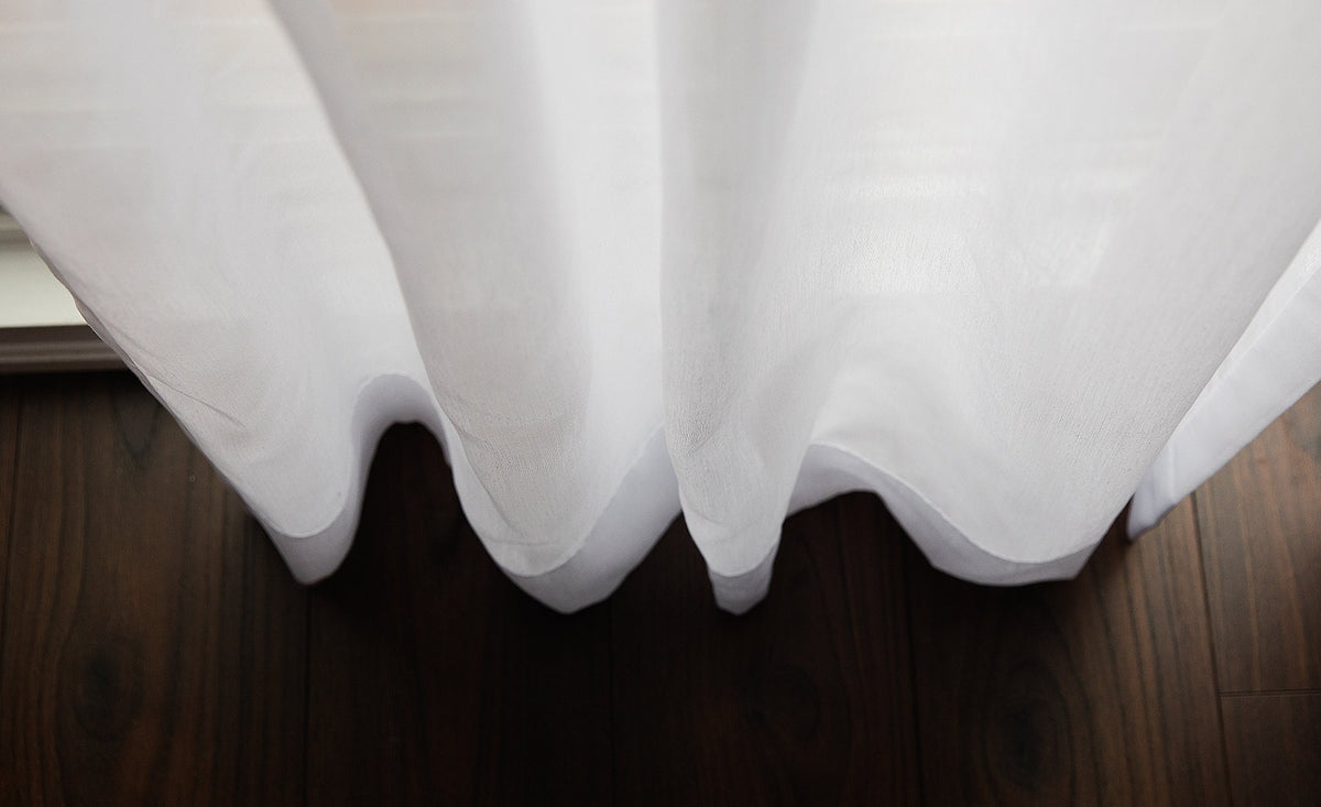 Dallas sheer drapery in soft folds over a dark wood floor