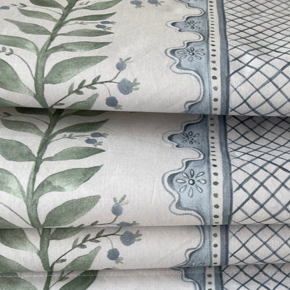 Celia fabric detail — green leaves and blue berries on cream with a blue geometric border