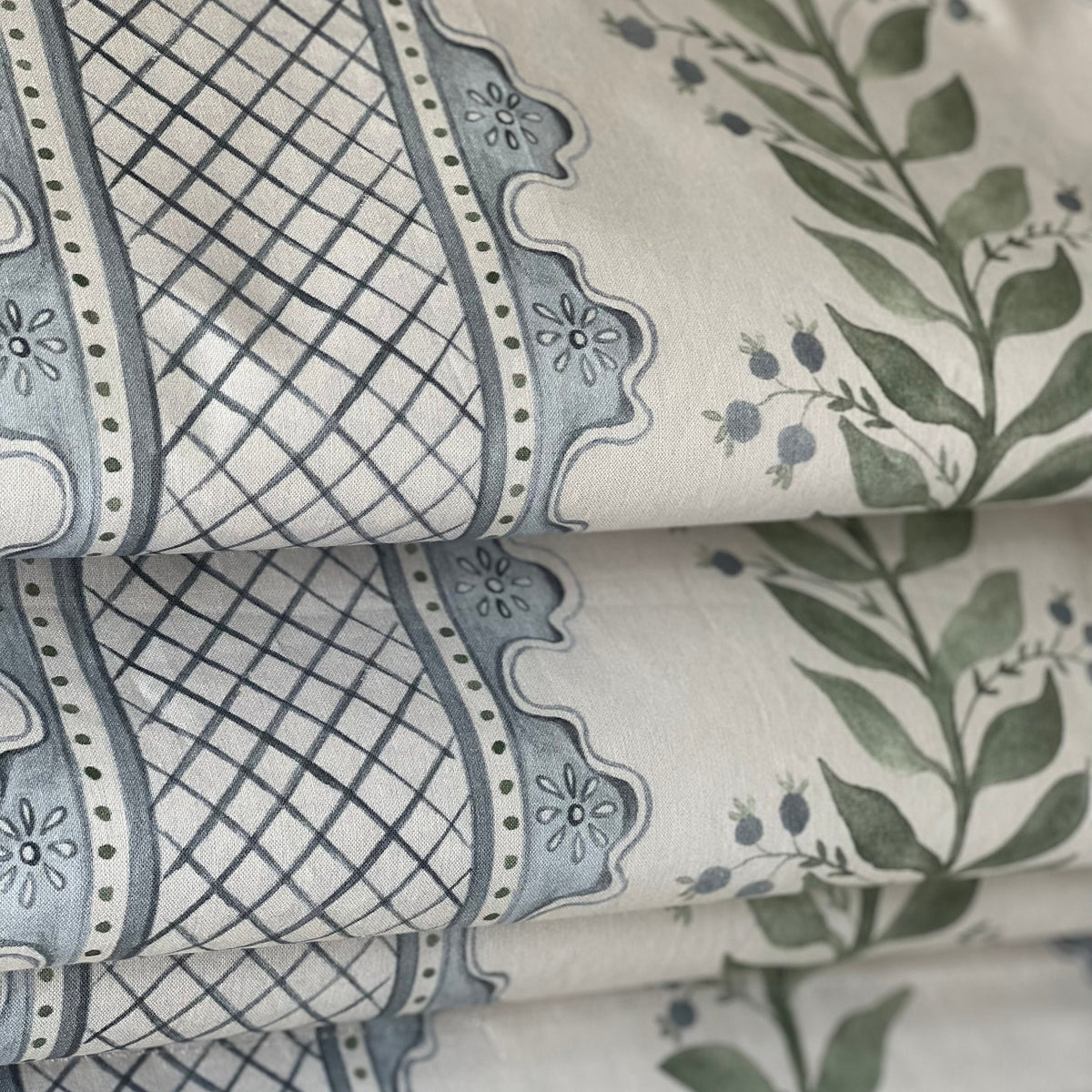 Close-up of the Celia lattice pattern in blue and green on a cream ground