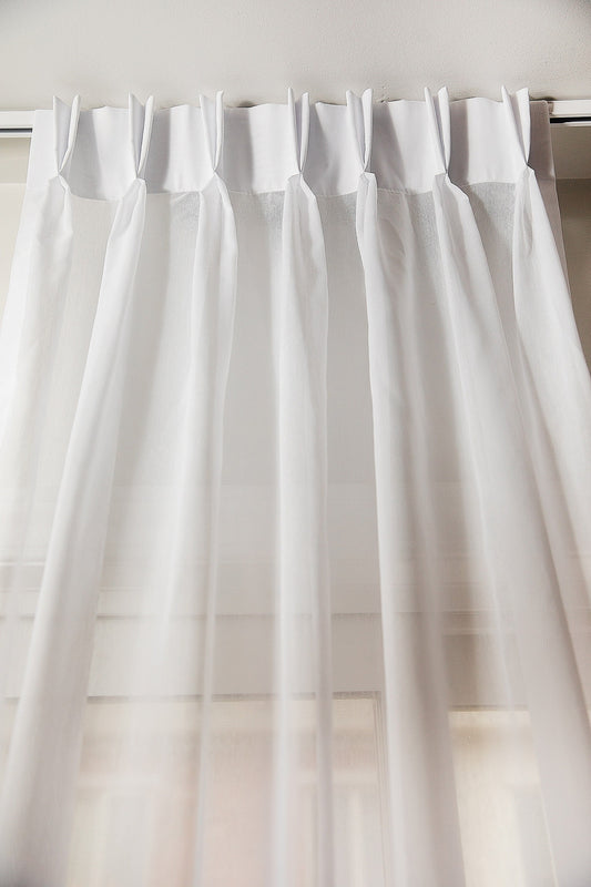 Dallas sheer double pleat drapery panel in white, hung on a track