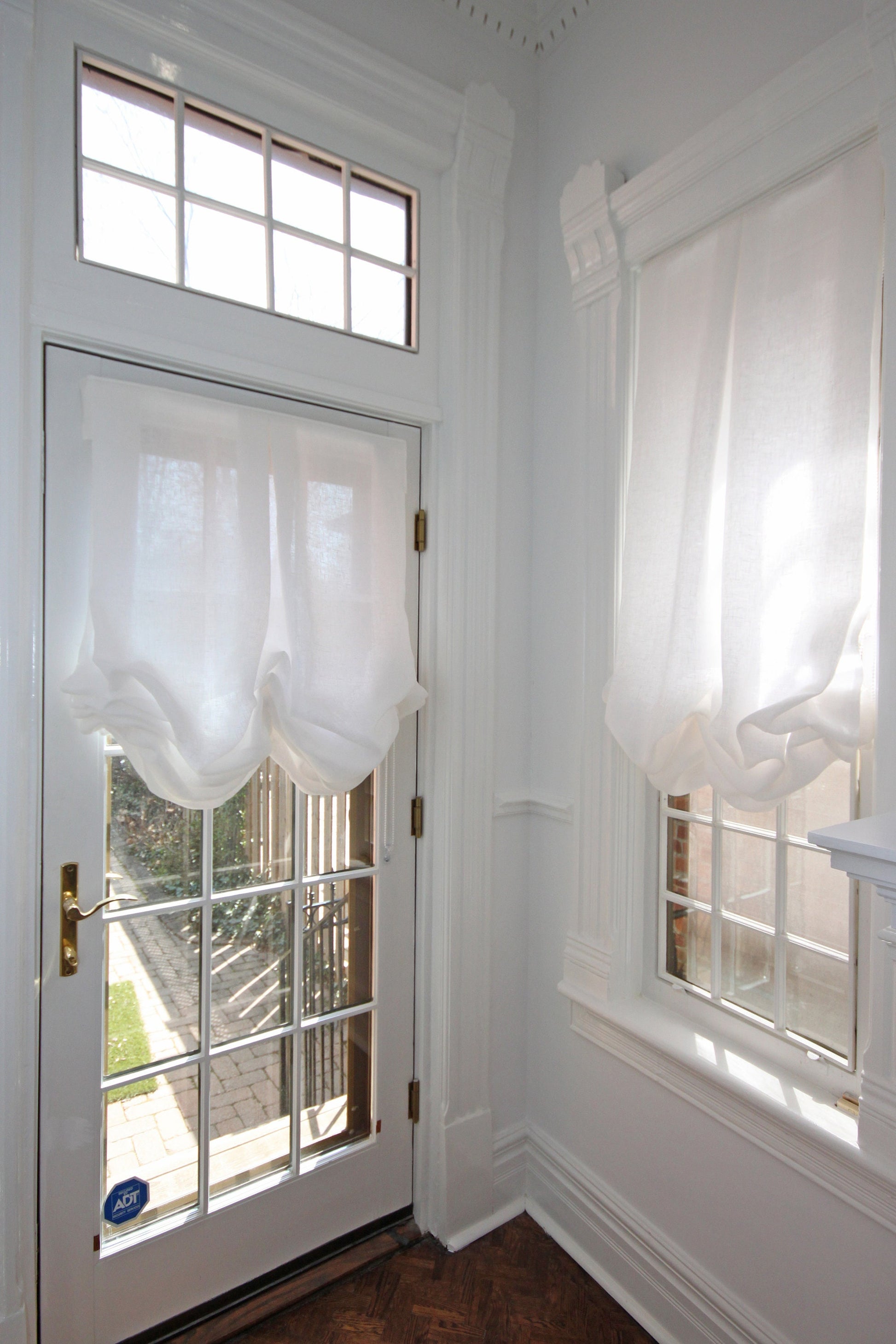 London tulip Roman shade in white Tuscany linen on a glass door and window — LOGANOVA