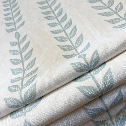 Soft blue linen shade with trailing white vine print, styled in a room