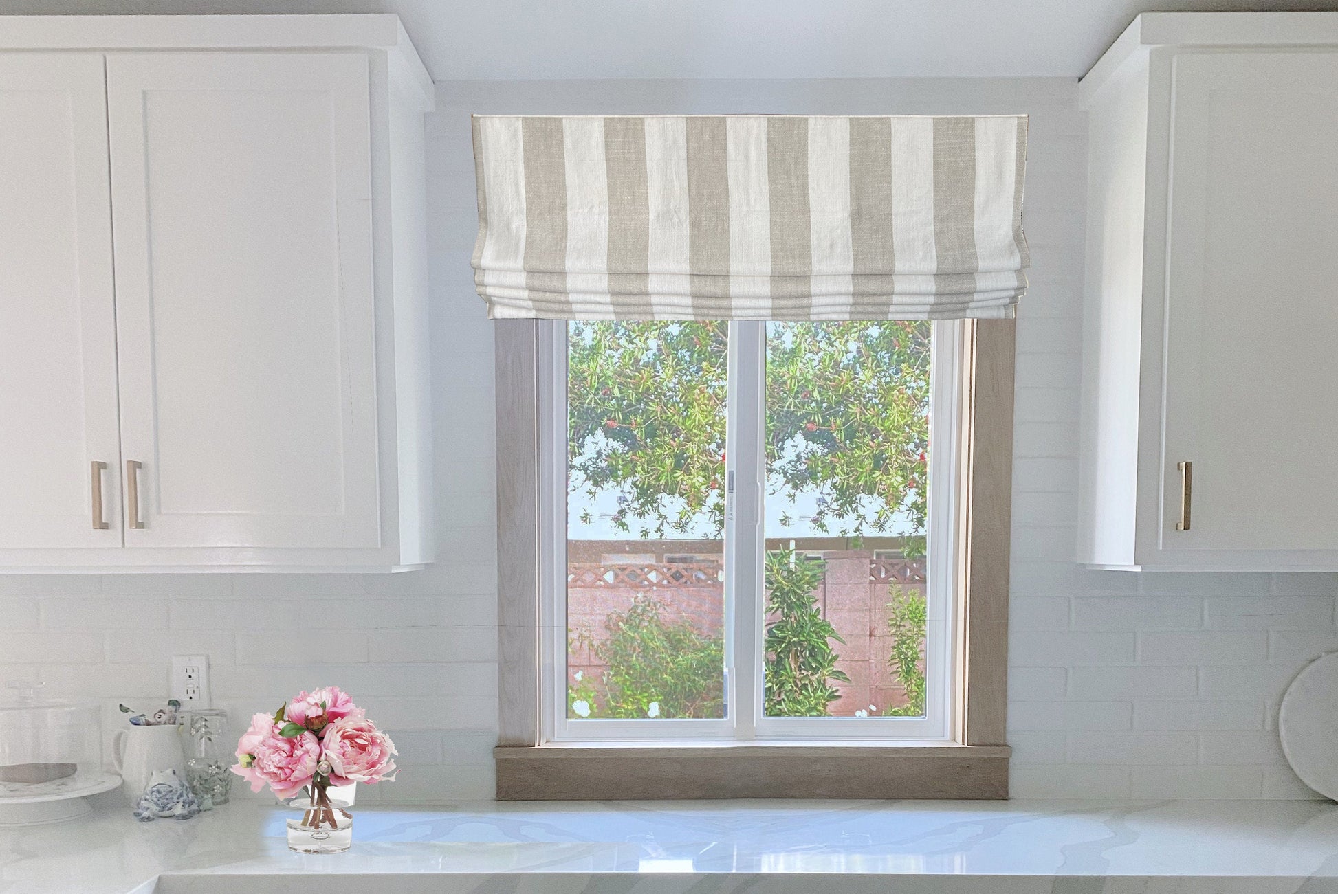 Copacabana relaxed linen Roman shade in a styled window, handmade in Toronto