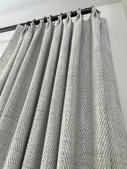 Corrie French pleat lined drapery panels in grey and white herringbone on a black rod