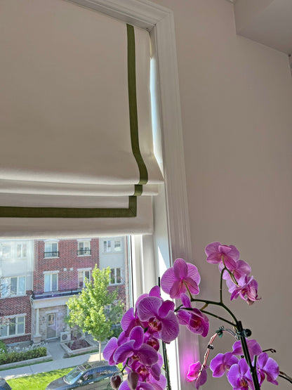 Cream linen roman shade with pine border, window view