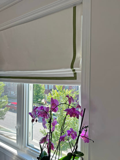 Cream linen roman shade with pine border, room view