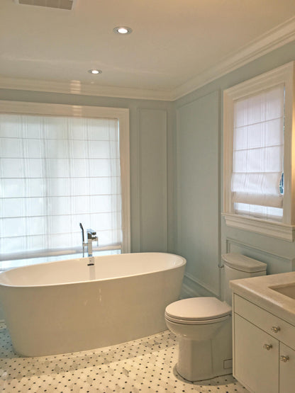 Spinello flat Roman shade in a light-blue bathroom setting