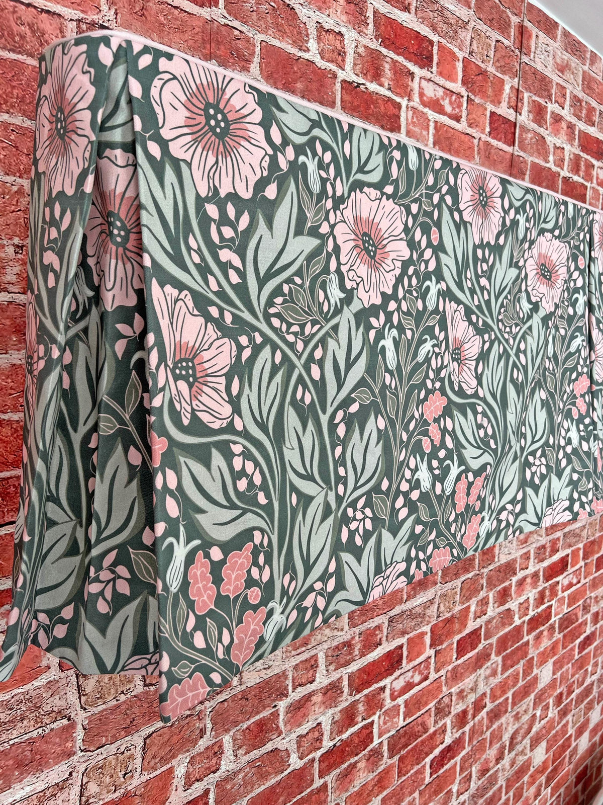 Floral pleated valance mounted on a brick wall