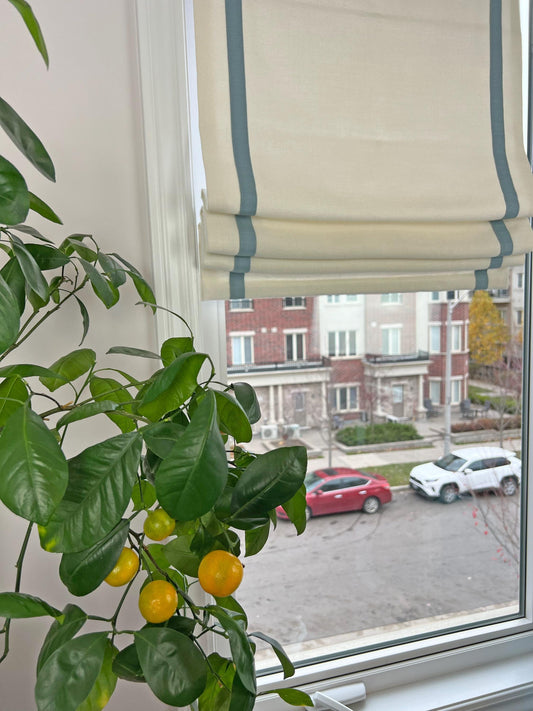 Relaxed Roman shade in faux linen with a 1 inch contrast border inset 2 inches, chain mechanism, custom made in Toronto