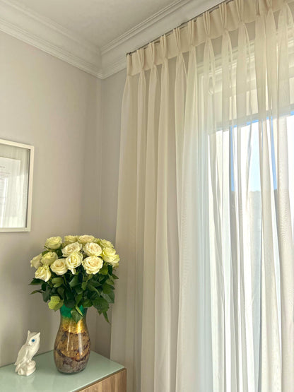 Empire voile triple pleat sheer panel at a bright window, white roses on the table — LOGANOVA