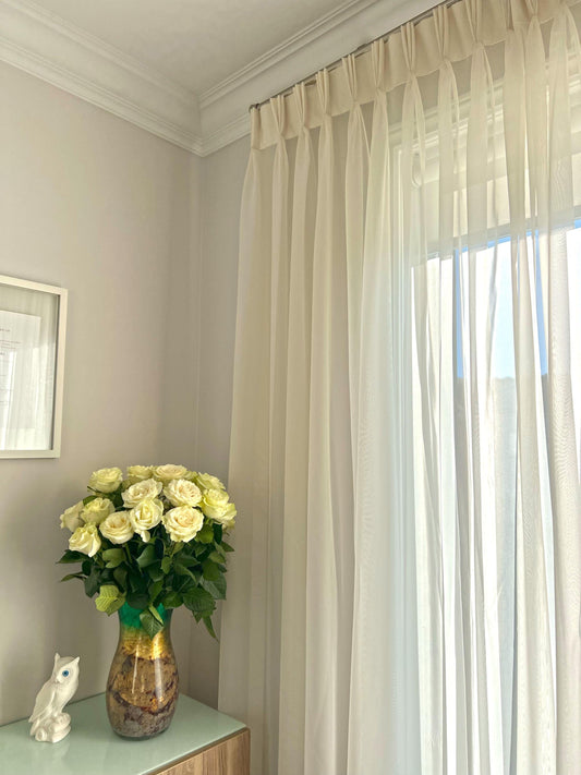 Empire voile triple pleat sheer panel at a bright window, white roses on the table — LOGANOVA