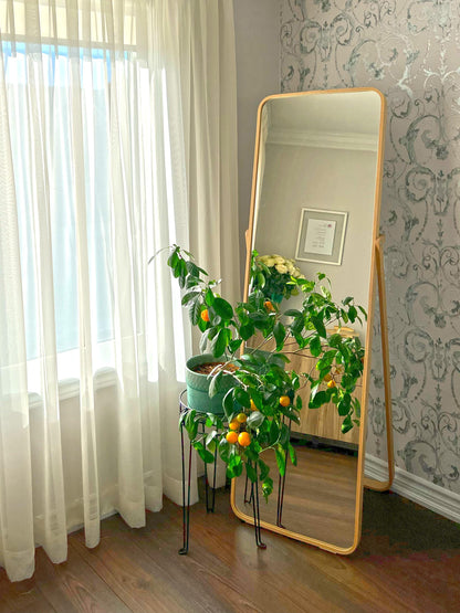 Triple pleat sheer voile panels behind a full-length mirror and citrus tree — LOGANOVA