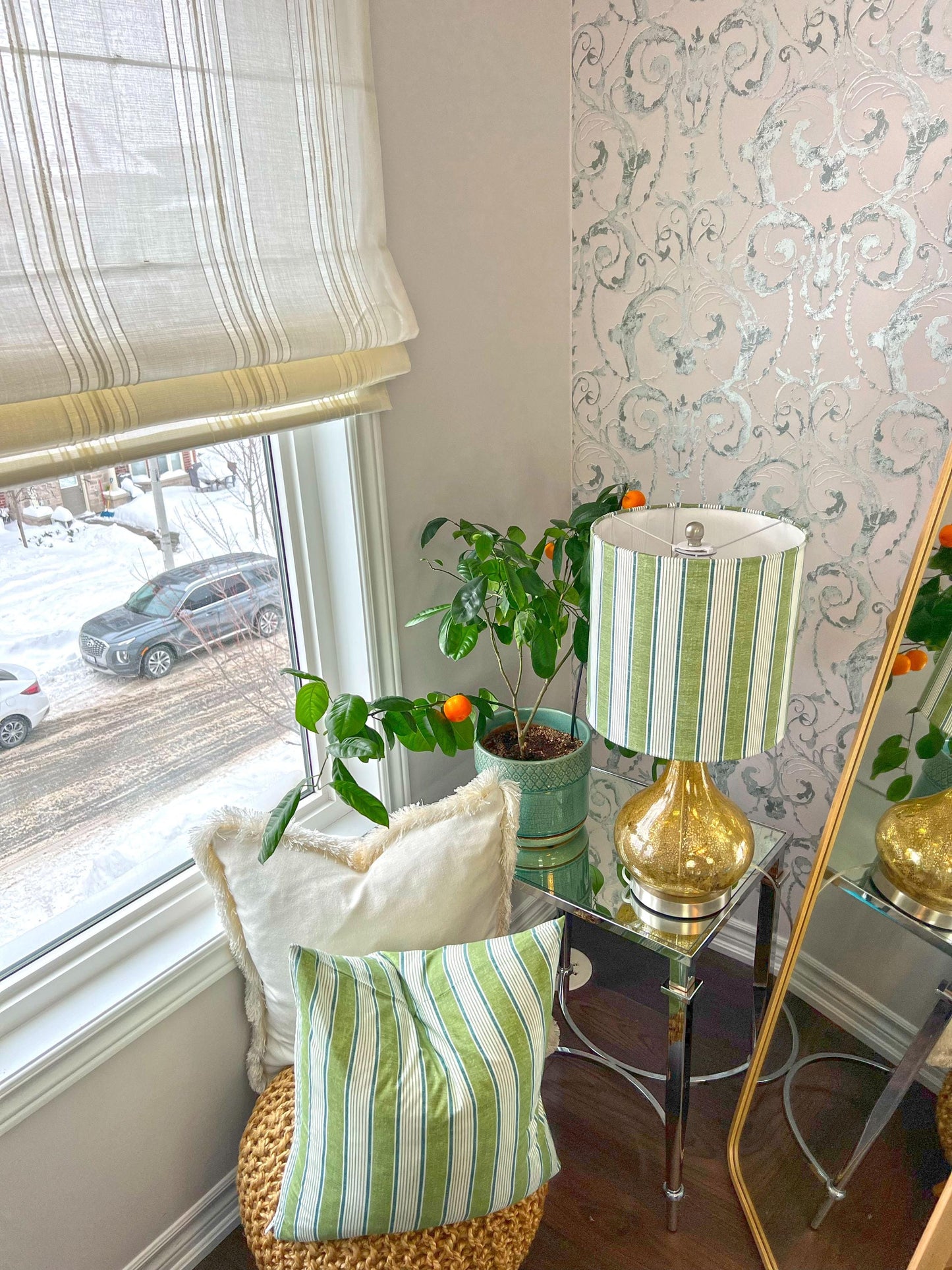 Spinello striped Roman shade styled in a room corner with plant and lamp