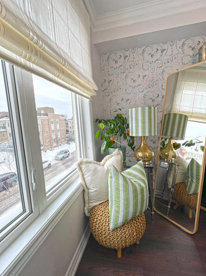 Spinello striped Roman shade in a living space with woven ottoman