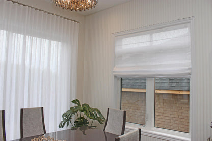 Relaxed Roman shade in Lugano faux linen filtering daylight at the window