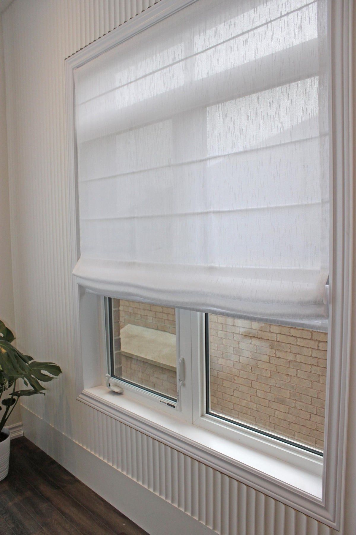 Lugano relaxed Roman shade raised, showing the gentle curve of the bottom edge