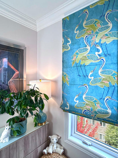 Deco Cranes Roman shade raised into soft relaxed folds — pool blue crane print