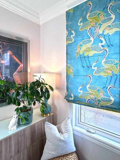 Deco Cranes patterned Roman shade in a styled corner with plant and lamp