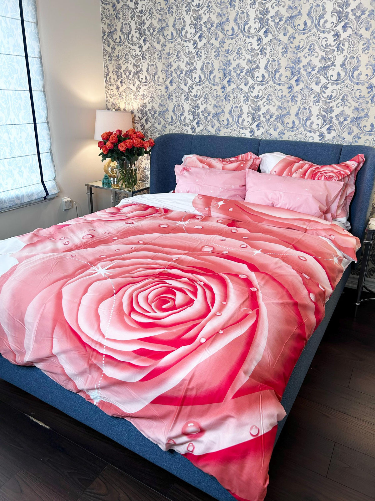 Pink rose print cotton duvet cover set on a made queen bed