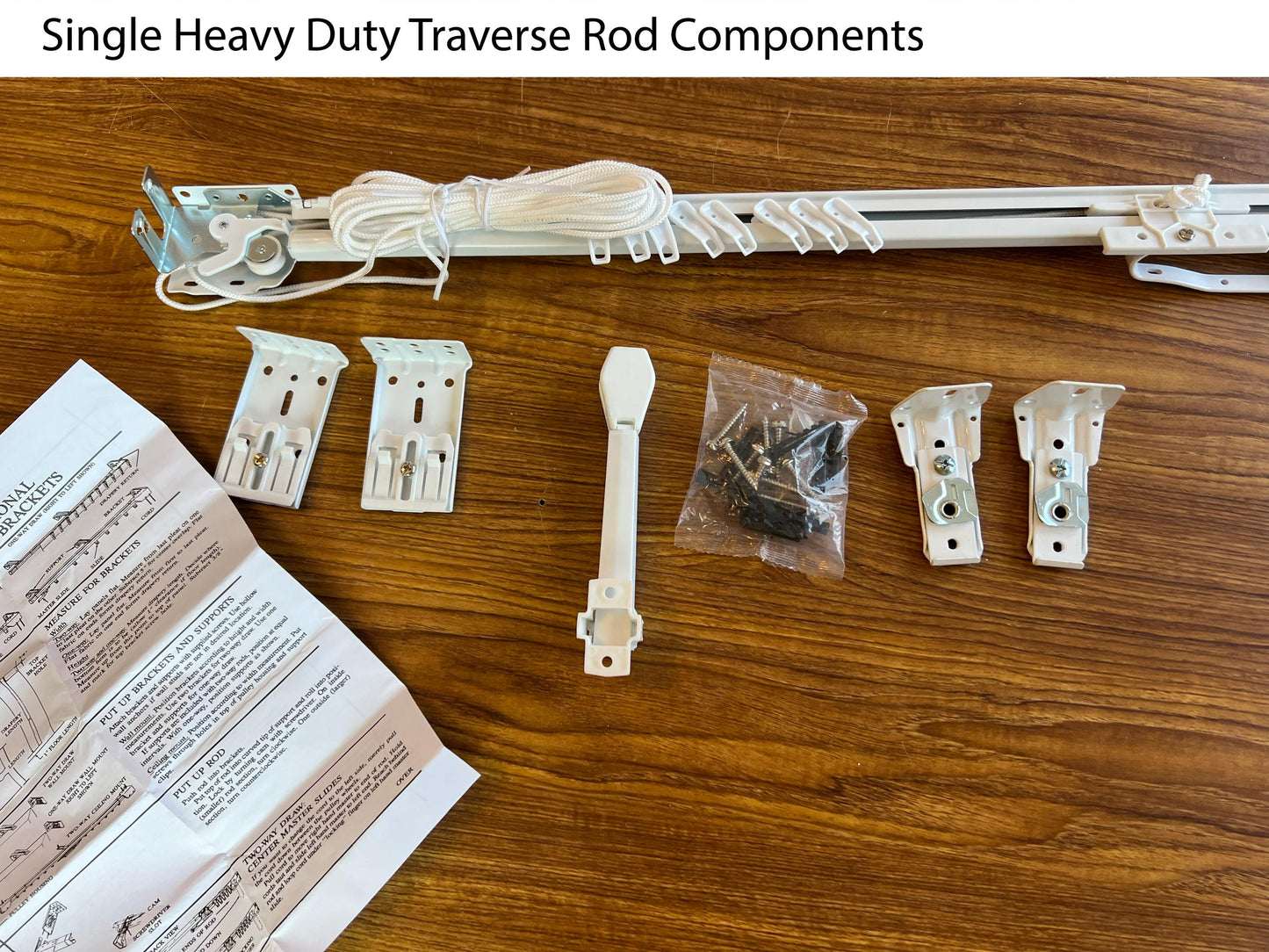 Heavy duty white traverse rod set with brackets, draw cord and hardware laid out — center open pinch pleat rod kit