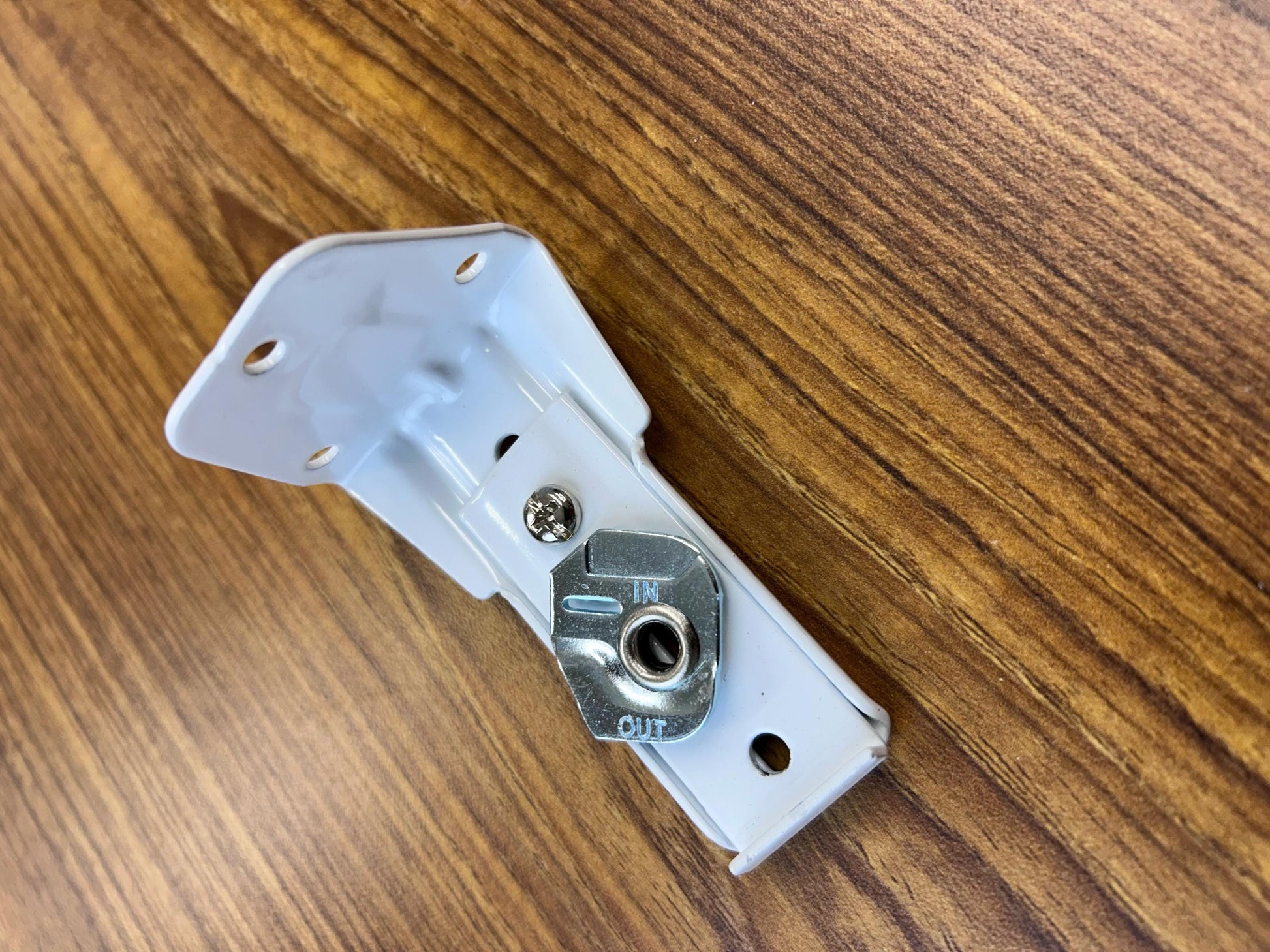 White metal support bracket with adjustment slots and screw — traverse rod mounting hardware