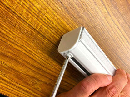 Close-up of chain clutch mechanism and end cap on white Roman shade track, replacement Roman blind hardware