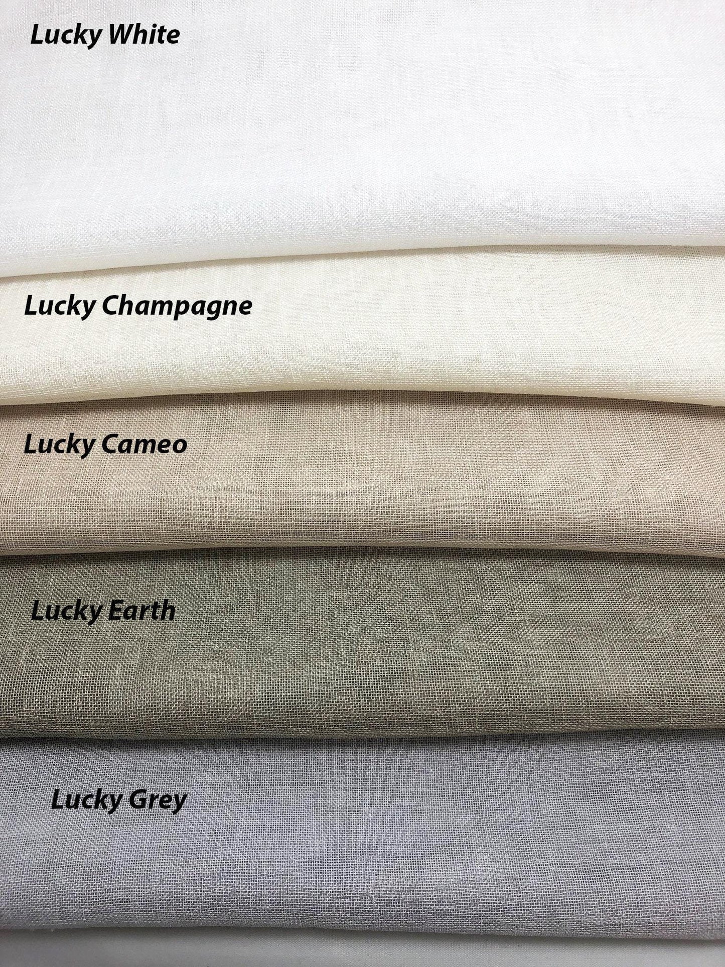 Lucky collection faux linen fabric samples for custom Roman shades and curtains: White, Champagne, Canvas, Earth and Grey folded textured swatches in neutral tones.