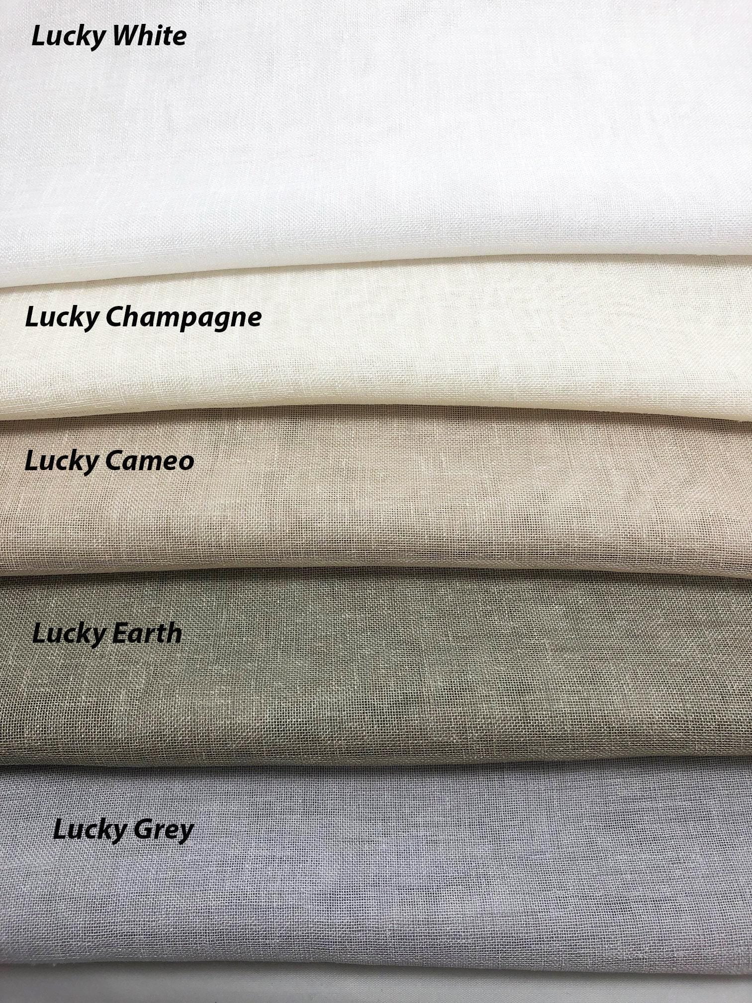 Lucky collection faux linen fabric samples for custom Roman shades and curtains: White, Champagne, Canvas, Earth and Grey folded textured swatches in neutral tones.