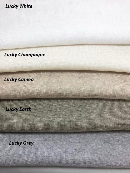 Lucky collection faux linen fabric samples for custom Roman shades and curtains: White, Champagne, Canvas, Earth and Grey folded textured swatches in neutral tones.